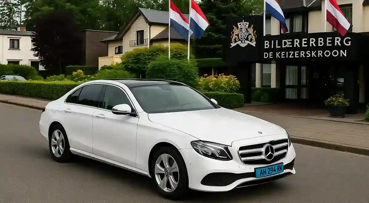 Een witte Mercedes van Taxi Modderkolk staat voor Hotel Keizerskroon in Apeldoorn