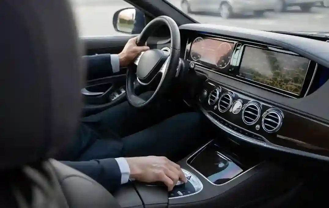 Een chauffeur zit in een luxe Mercedes van Taxi Modderkolk
